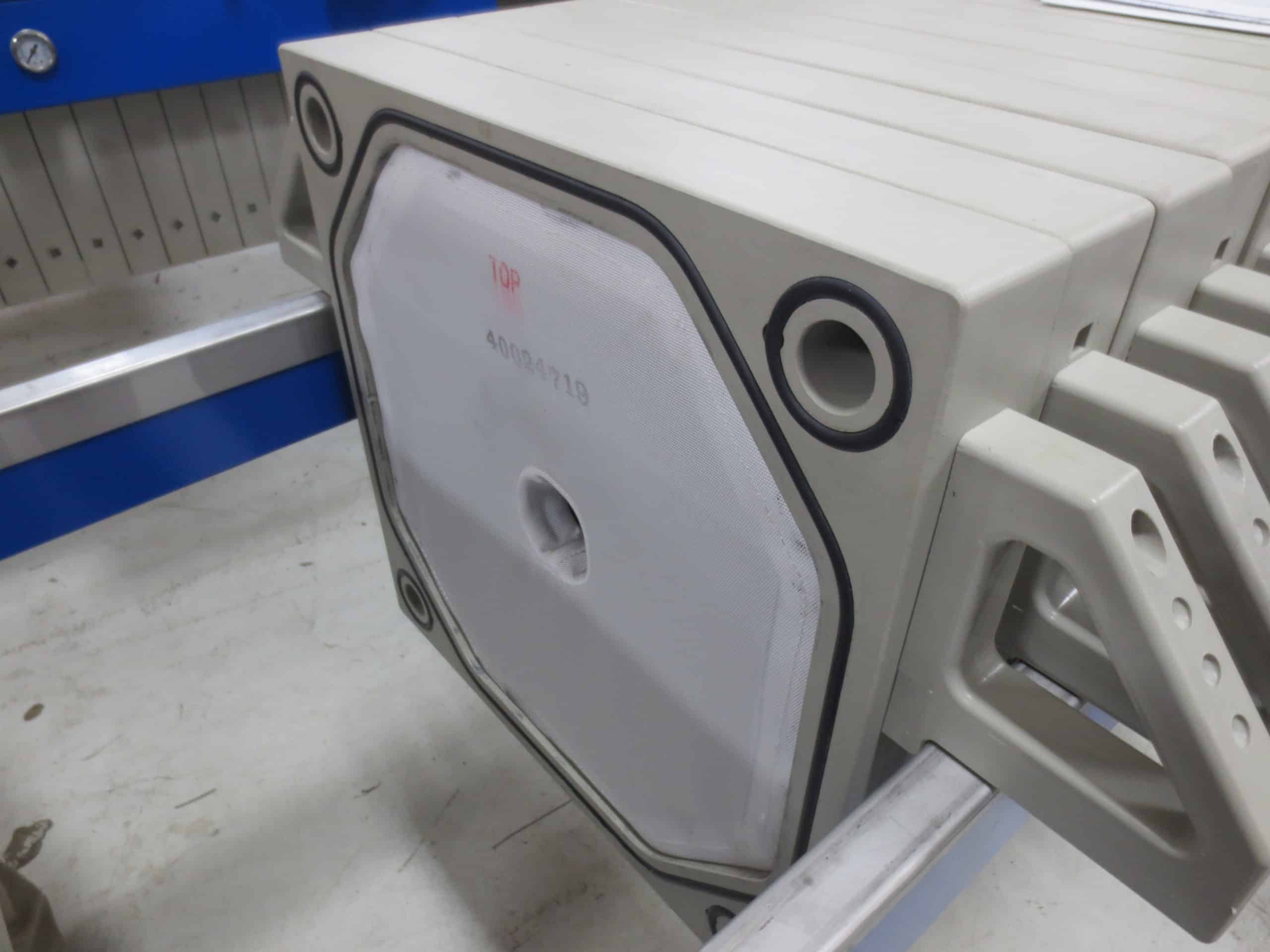 M.W. Watermark Gasketed Filter Plates with Filter Cloths Installed. Particulates Accumulate on the Surface of the Cloths to Form a Filter Cake.